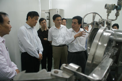 繆曉青教授向省委常委、常務副省長張昌平介紹自己研發的高節能保鮮濃縮干燥機和疊壓高能保鮮濃干燥機